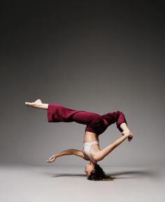 a woman doing a handstand on one leg