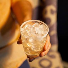 a person holding a glass with ice in it