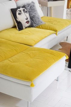 two yellow and white couches with pillows on them