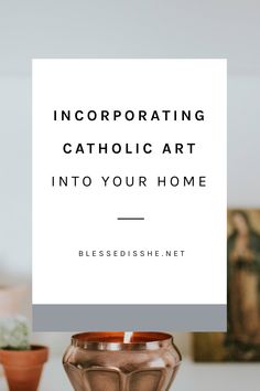 a table topped with a vase filled with flowers next to a white sign that says incorporating catholic art into your home