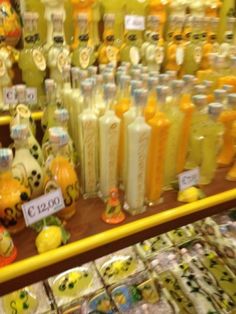 there are many different bottles on display in the store, one is yellow and the other is white