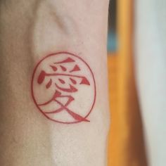 a small red tattoo on the arm of a person's left arm and wrist