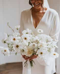 a woman holding a bouquet of white flowers