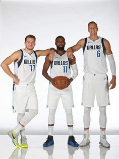 three basketball players are posing for a photo