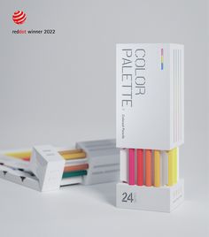 a stack of colored pencils sitting next to each other on top of a white table