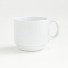 a white coffee cup sitting on top of a table