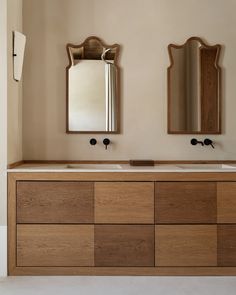 a bathroom with two sinks and mirrors on the wall