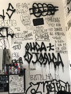 black and white graffiti on the wall of a bar in an alleyway with writing all over it