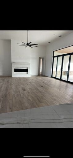 an empty living room with wood floors and sliding glass doors