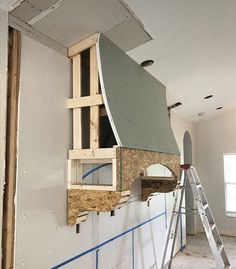 an unfinished room with a ladder and window in the wall that is being built into the wall