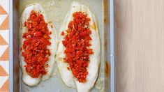 two fish fill the pan with sauce and seasoning on top, ready to be cooked