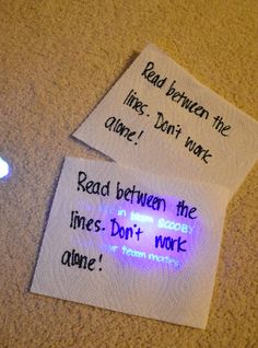 two pieces of paper with words written on them next to a cell phone and light bulb