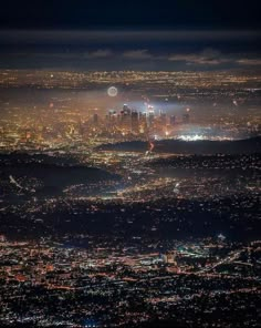 an aerial view of the city lights at night from above, with fog in the air