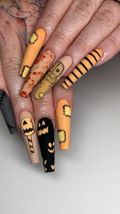 a woman's hand with halloween themed nails and nail art on her fingers,