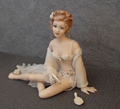 a doll is sitting on the floor with her legs spread out and hands in front of her body