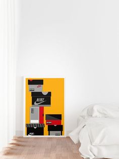 a white bed sitting next to a yellow and black poster on the wall in a bedroom