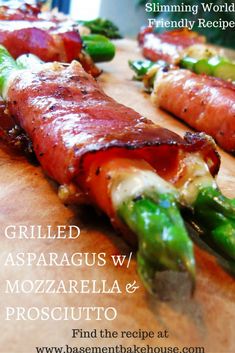 grilled asparagus w / mozzarella & prosciutto on a cutting board