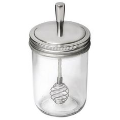 a glass jar with a metal lid and a wire in the middle on a white background