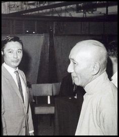 two men standing next to each other talking