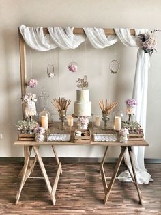 a table topped with two cakes covered in white frosting and flowers next to candles