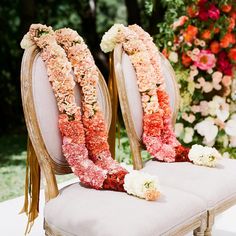 two chairs with flowers on them sitting next to each other