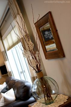 a living room filled with furniture and a glass vase on top of a coffee table