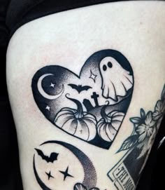 a woman's thigh with tattoos on it and two pumpkins in the shape of a heart