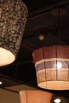 two lamps hanging from the ceiling in a room with other lighting fixtures and lightshades