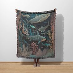 a woman standing in front of a tapestry with dolphins on it