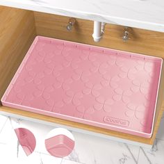 a pink bath mat sitting on top of a sink