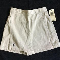 Classic Khaki Skirt From Ralph Lauren With The Navy Blue Logo, Size 6x And Nwt (Tags Specs: Size 6x: 48.5-50.5 Inches, 47-53 Pounds). Waist Is Elastic In Back For A Comfortable Fit. Has Attached Modesty Shorts Underneath. Measures 10.5 Flat Across The Waist (Unstretched). Length From Top Of Waistband To Hem Is 11.5 Inches. Check Out My Other Listings For More In This Size For Custom Bundle Options. Ralph Lauren Mini Skirt For Spring, Ralph Lauren Spring Mini Skirt, Spring Mini Skirt By Ralph Lauren, Casual Beige Tennis Skirt For Spring, Casual Fitted Beige Skort, Casual Beige School Skirt, Beige Spring Skort For School, Casual Cream Mini Length Skort, Cotton Skort With Pockets