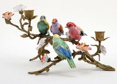 a group of birds sitting on top of a tree branch with flowers in the background