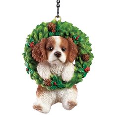 a christmas ornament with a dog hanging from it's front paws and wearing a wreath