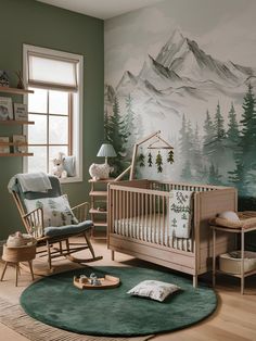 a baby's room decorated in green and white with mountains painted on the wall