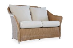 a wicker couch with two white pillows on it's back and sides, against a white background