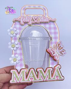 a hand holding up a pink and white card with the word mamma in it