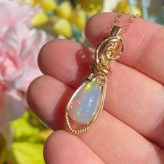 This gorgeous Ethiopian Opal pendant is hand wrapped using elegant 14k yellow gold fill wire. It is a dark base opal with stunning colors consisting of all the colors of the rainbow with a gorgeous play of color. The opal weighs 4.2 carats before wrapped.  This pendant measures just a hair under 1.5 inches tall from the bottom of pendant to the top of the bail. A 14k gold fill chain is available upon purchase (as seen in photos). Chain is removable and interchangeable.  I did my best to provide Unique 14k Gold Wire Wrapped Jewelry, Hand Wrapped Yellow Gold Jewelry As Gift, Hand Wrapped Yellow Gold Jewelry Gift, Hand-wrapped Yellow Gold Jewelry Gift, One Of A Kind Opal Jewelry Gift, Yellow Gold Wire Wrapped Jewelry For Healing, Handmade Yellow Gold Opal Jewelry, Handmade Opal Jewelry In Yellow Gold, Unique Hand Wrapped Opal Jewelry