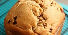 a close up of a muffin on a cooling rack with a blue towel in the background