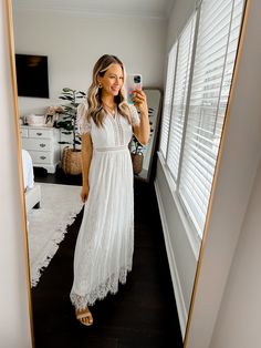 a woman is taking a selfie in the mirror with her cell phone while wearing a white dress