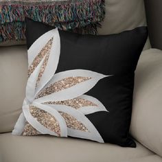 a black and white pillow sitting on top of a couch next to a beige chair