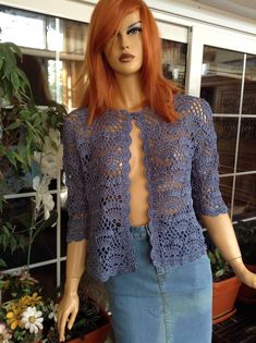 a mannequin wearing a blue crochet top and denim skirt with red hair