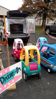 several toy cars parked in a parking lot next to a sign that says drive - n