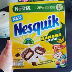 someone holding up a box of nestle nepsquik cereal