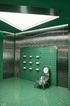 a public restroom with green tiled walls and floor