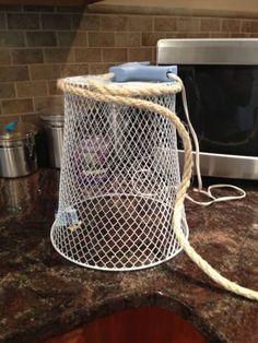 a white wire basket sitting on top of a counter next to a toaster oven