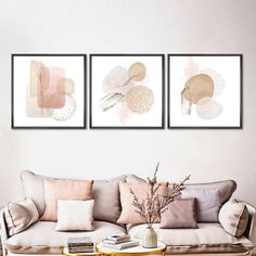 three paintings on the wall above a couch in a living room with a coffee table