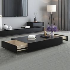 a modern living room with grey carpeting and black coffee table in front of a large mirror