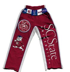 Celebrate the pride and legacy of South Carolina State University with the SC State Tag'Em Up Pants. These sweatpants are designed for Bulldogs who want to showcase their school spirit in style and comfort. Crafted from premium fleece cotton, the pants feature bold garnet side panels and white piping that represent the university’s iconic colors. The puff screen print logos on both legs highlight SC State’s Bulldog mascot and other key emblems, making a statement wherever you go. Perfect for gam South Carolina State University, Custom Woven Labels, Bulldog Mascot, University Logo, School Events, The Pride, Pants Large, Woven Labels, School Spirit