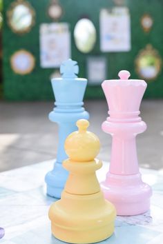 three different colored chess pieces sitting on top of a table