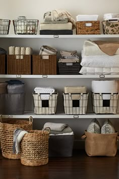 the shelves are filled with baskets, blankets and other things to put on top of them